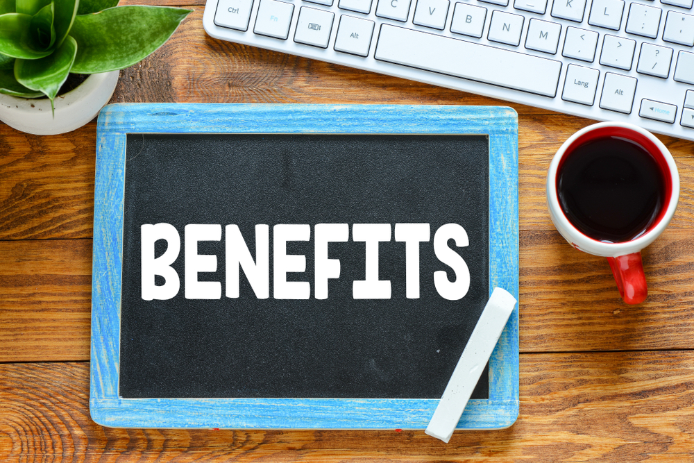 benefits message in white chalk letters written small black chalkboard over a wooden desk to represent Bitcoin Merchant Account