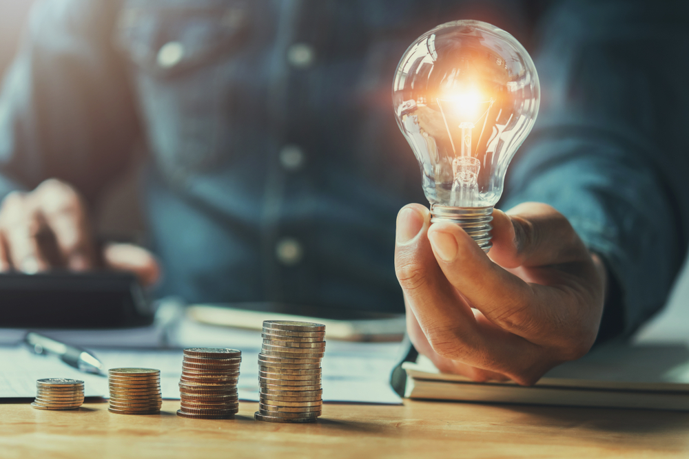 businessman hand holding light bulb while doing accounting 