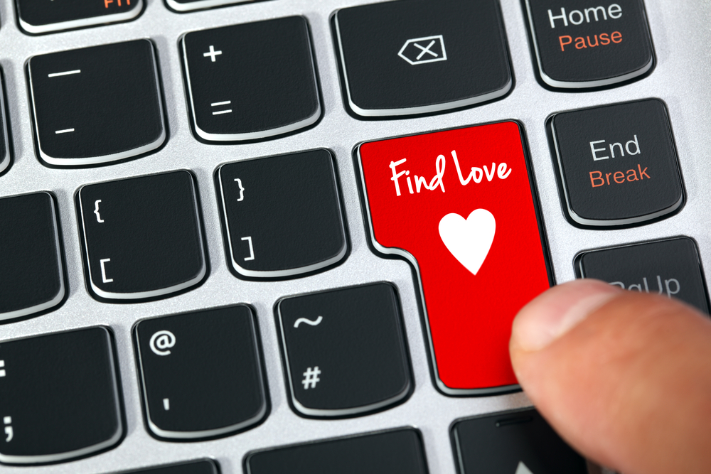 Computer keyboard key with find love and heart icon concept to represent Dating Merchant Account