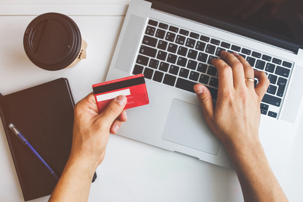 Top view of man using credit card for online shoping symbolized Casino Merchant Account