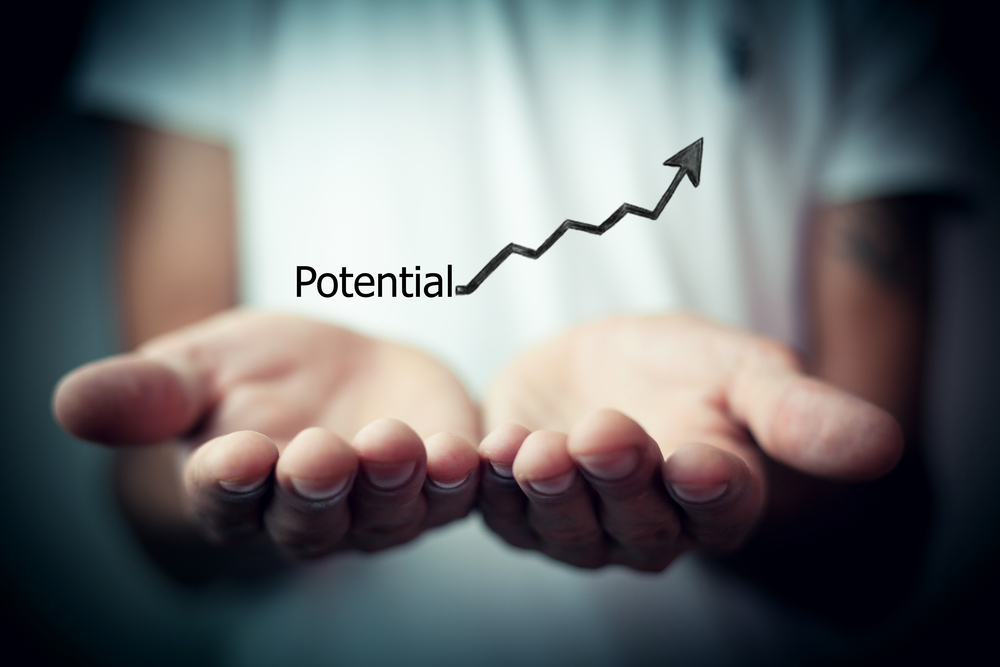 Hands holding an exponential arrow graph with the word potential to represent Merchant Account vs Payment Gateway