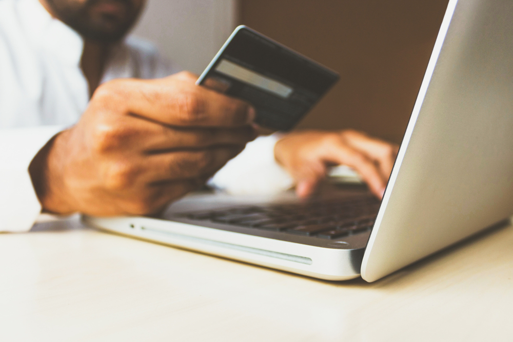  man use credit card for shopping payment online on laptop computer to represent Online Payment Gateways