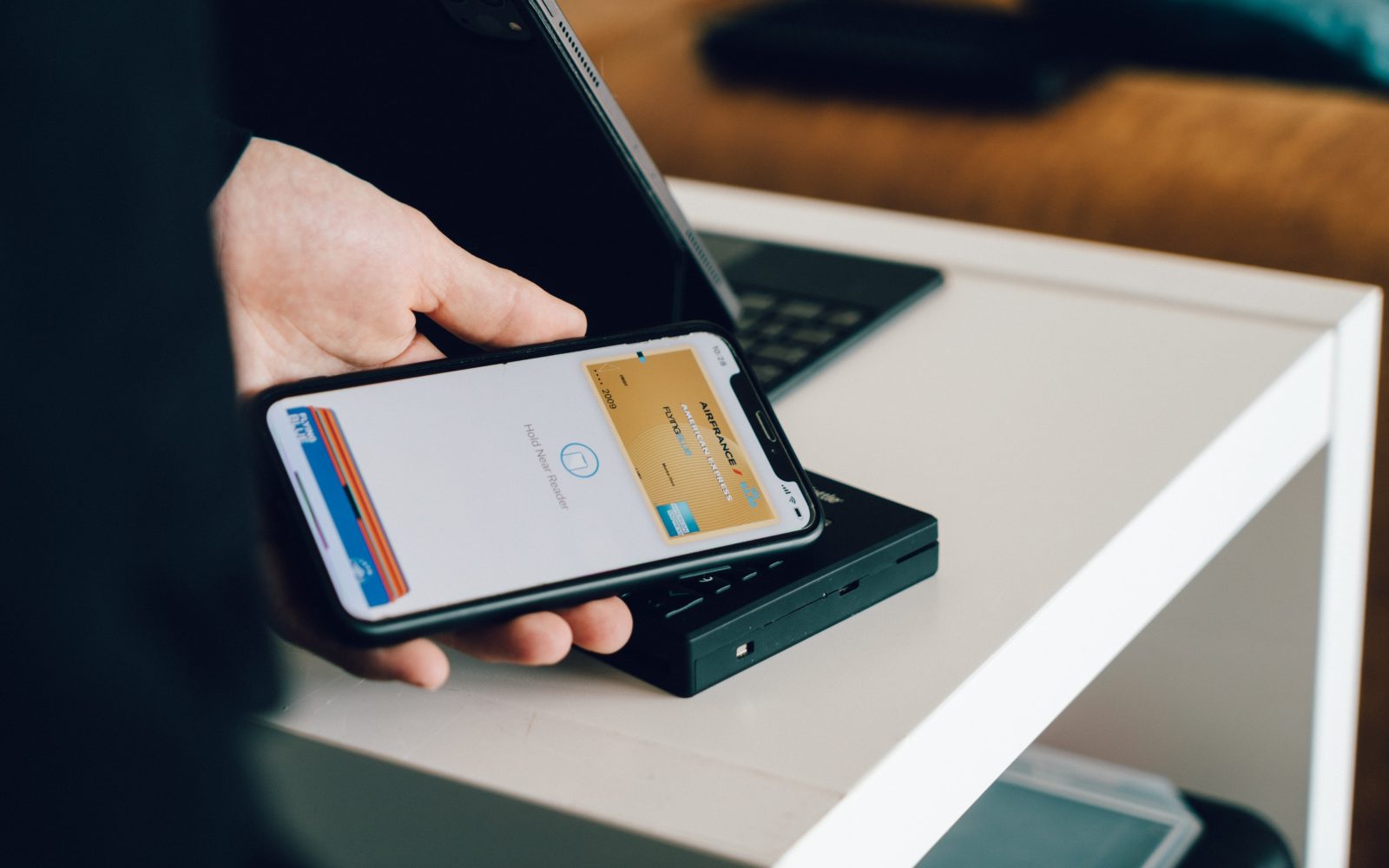 Cropped image of man's hands holding a smartphone and doing a payment by using a NFC technology 