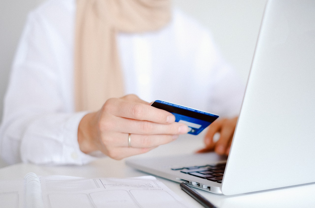 Female hands holding credit card and using laptop. Online shopping to symbolized High-Risk Merchant Account
