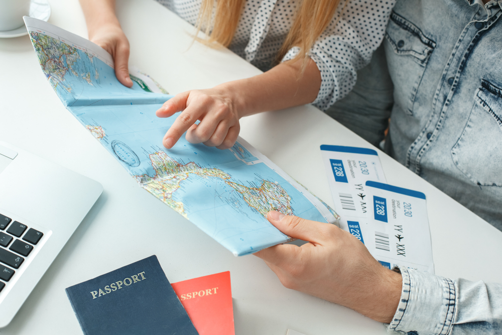 Young couple in a tour agency travelling concept choosing destination close-up.