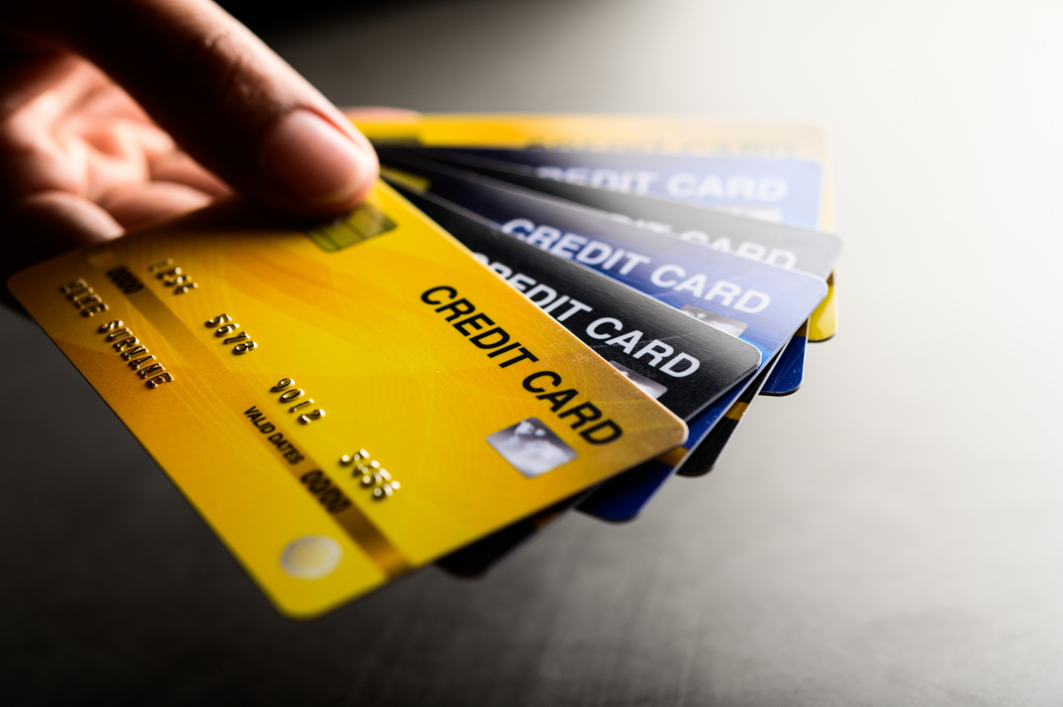 close up of a man holding several credit card to Collection Agency Merchant Services