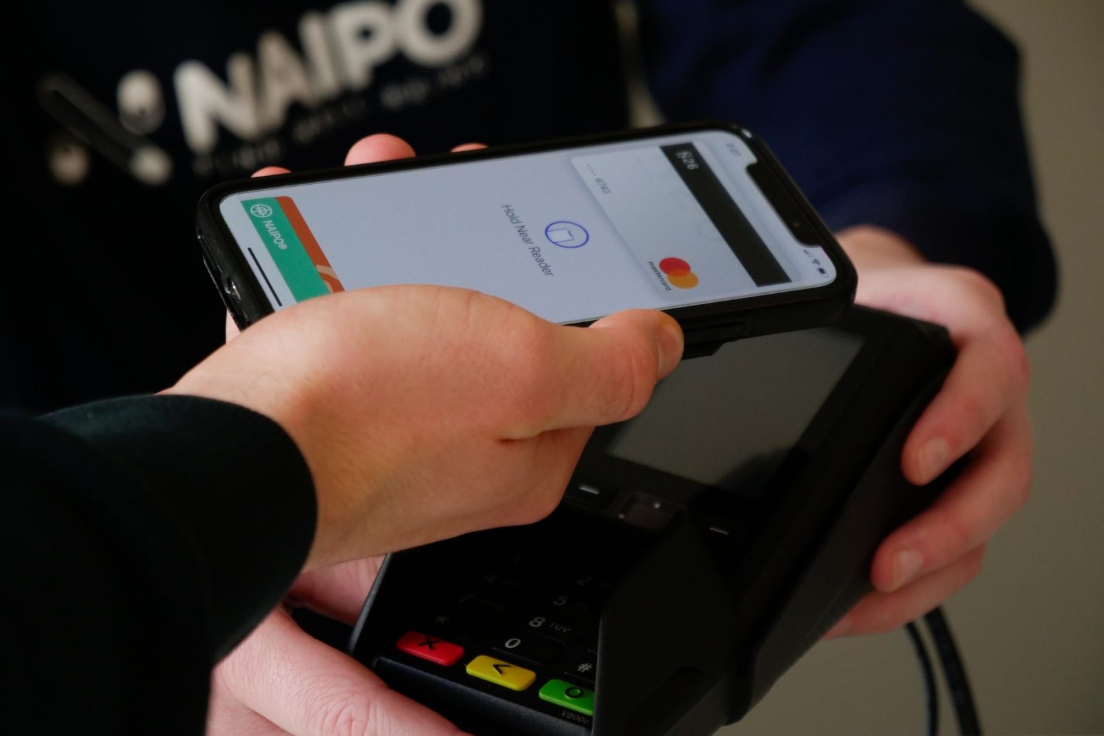 Close-up of a man paying a bill through a smartphone using NFC technology for Electronic Payment Process