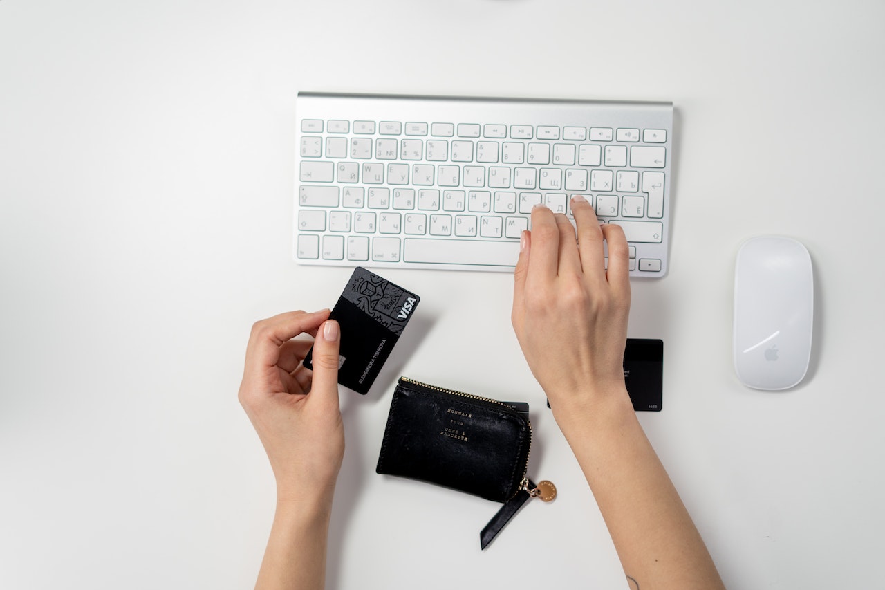 woman typing on a white keyboard about to make a purchase online to represent Adult Merchant Business Accounts