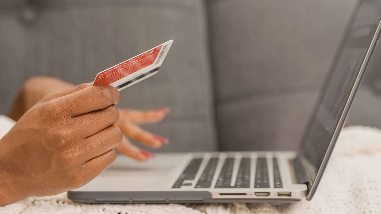 Close up look at a women's hands doing online shopping using her laptop and credit card to represent Ecommerce Payment Processing