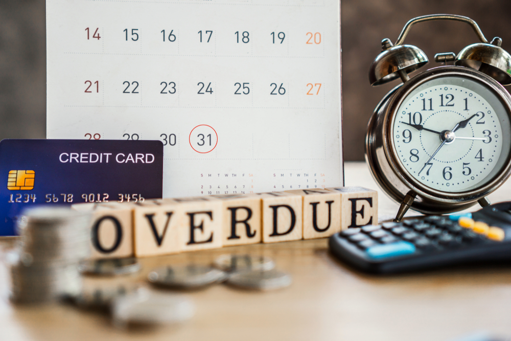 overdue bills concept with deadline calendar remind note,coins,credit card,calculator on table