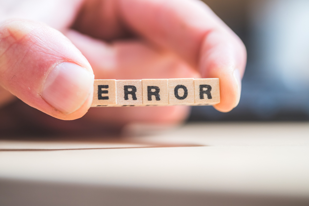 A person holding the blocks that spell out the word error referring to check processing errors.