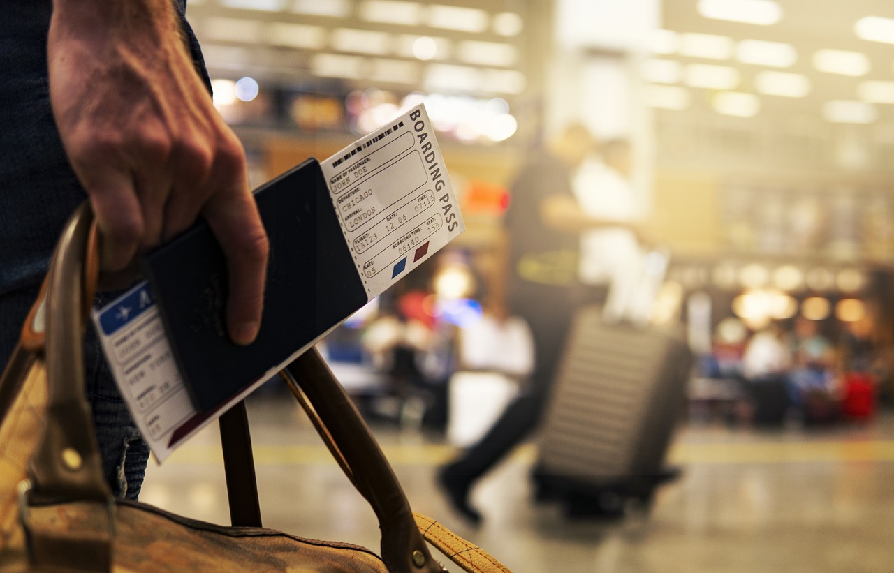 man in hand showing passport and boarding pass to show travel