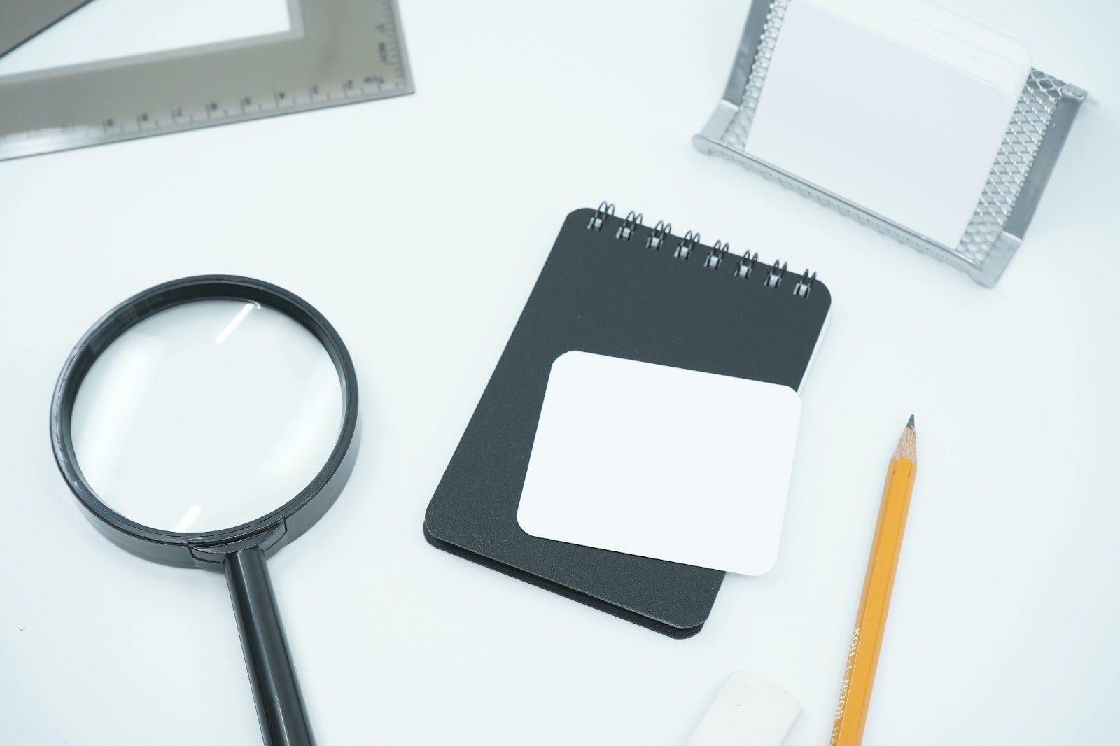 Magnifying glass and notebook to symbolize what to look for in a cryptocurrency payment processor