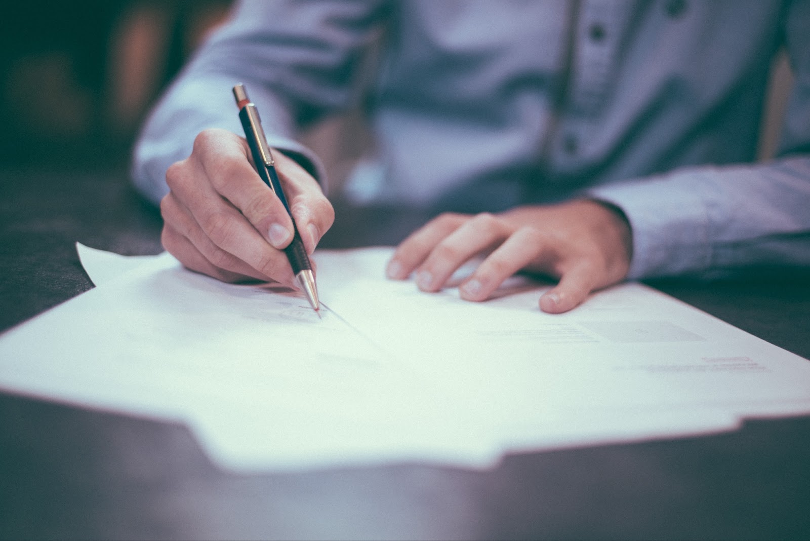 Person signing papers to symbolize customer financing for small business