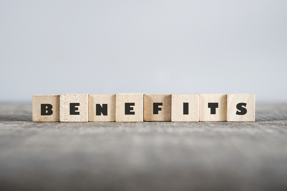 The word benefits is spelled out with wooden blocks.