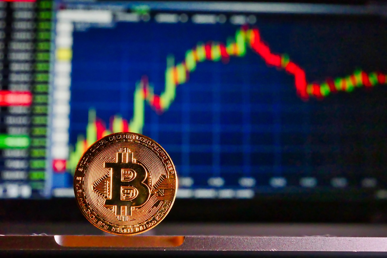 Bitcoin positioned in front of a stock chart
