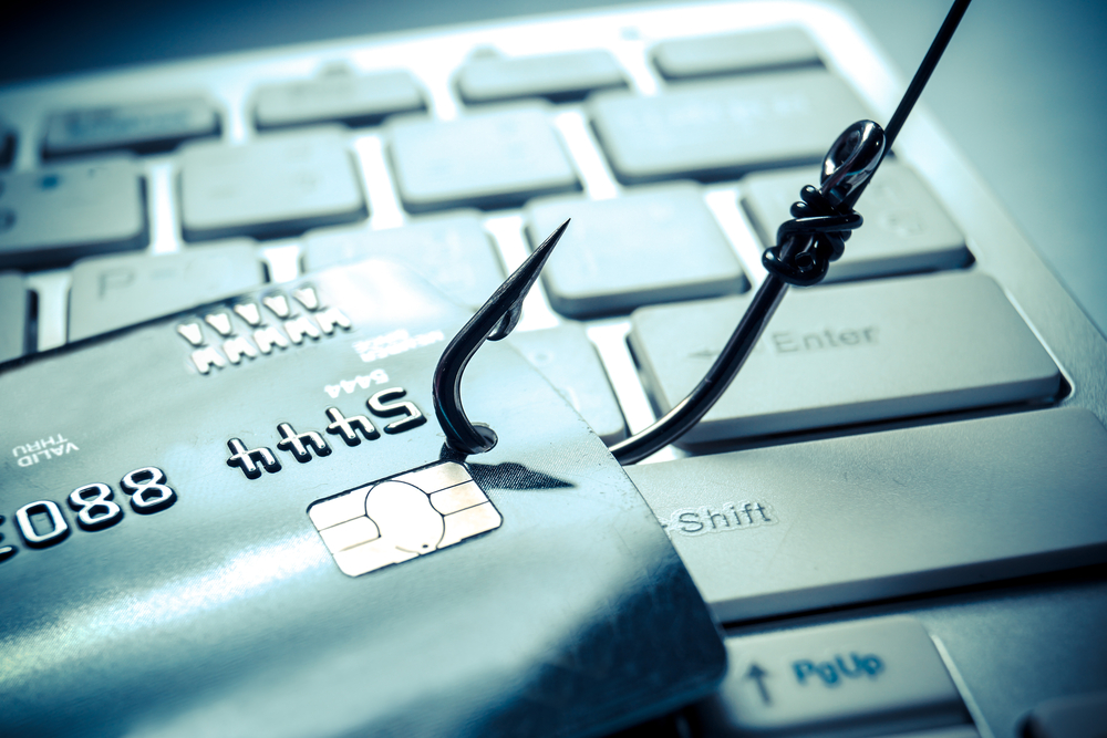 A credit card being hooked on top of a keyboard