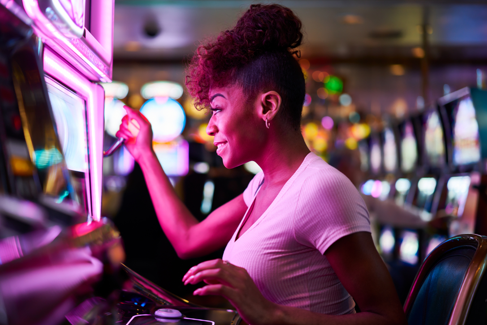A woman playing a slot machine symbolizes the gambling industry, one type of business that is high-risk.