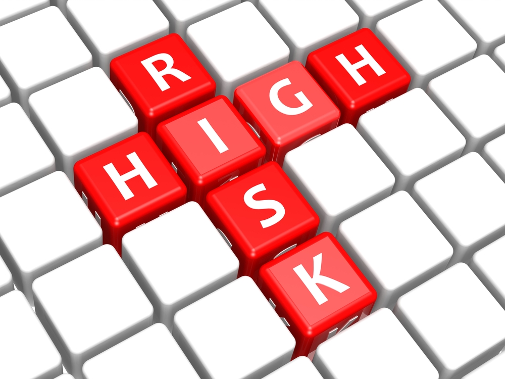A keyboard spelling out the word risk vertically being crossed by the word high 
horizontally with red keys and white writing.