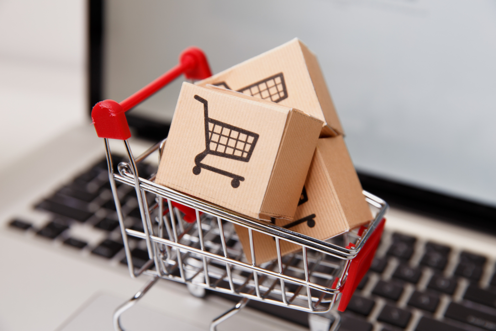 Many paper boxes in a small shopping cart on a laptop keyboard