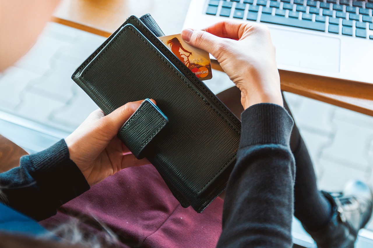 A person pulling a bank card out of a wallet.