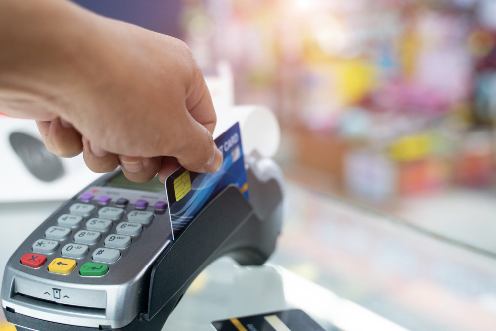 A person swiping their card into a credit card terminal for a cannabis product.